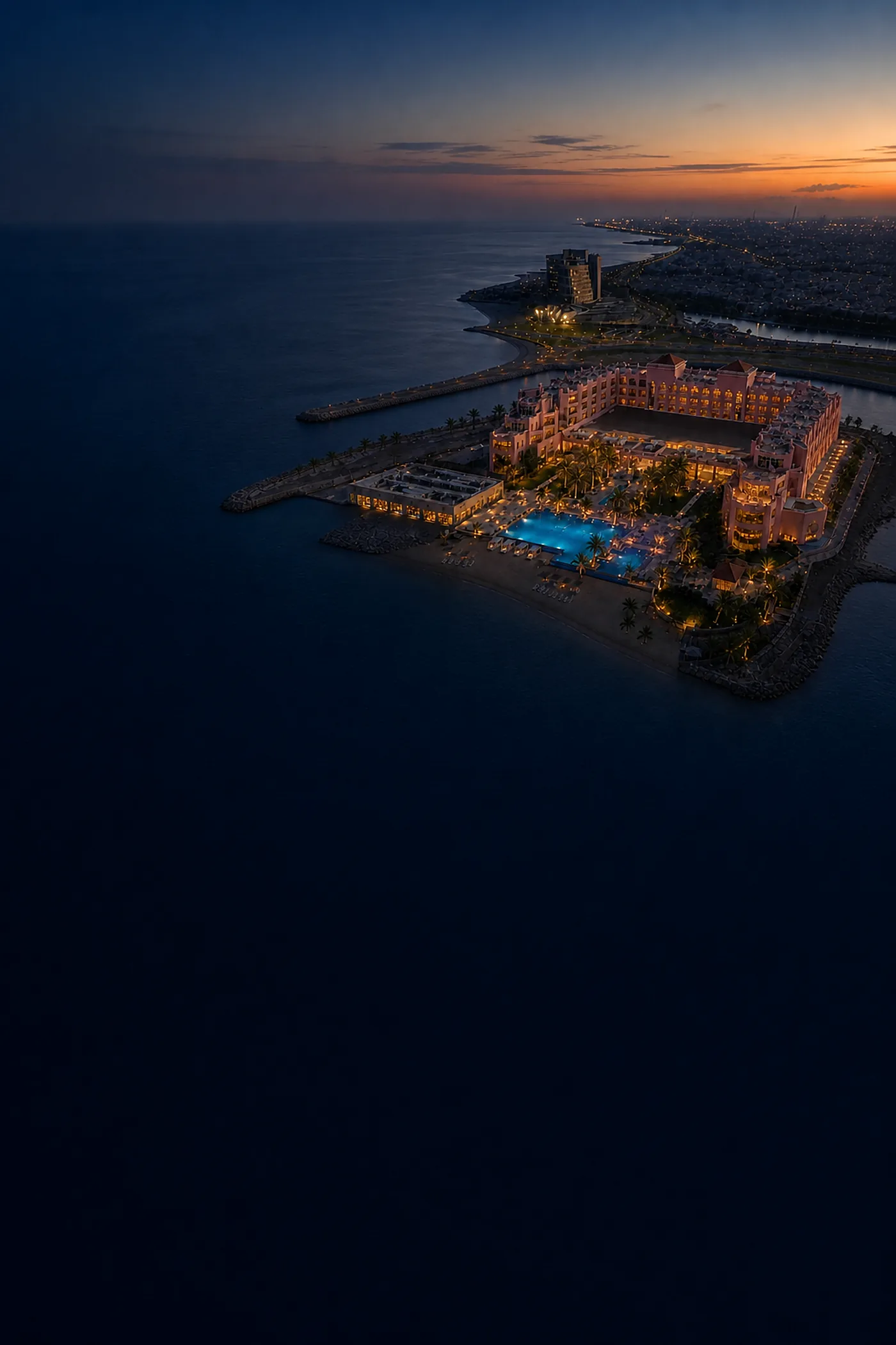Sariya Hotel on its headland at dusk, lit against the Red Sea