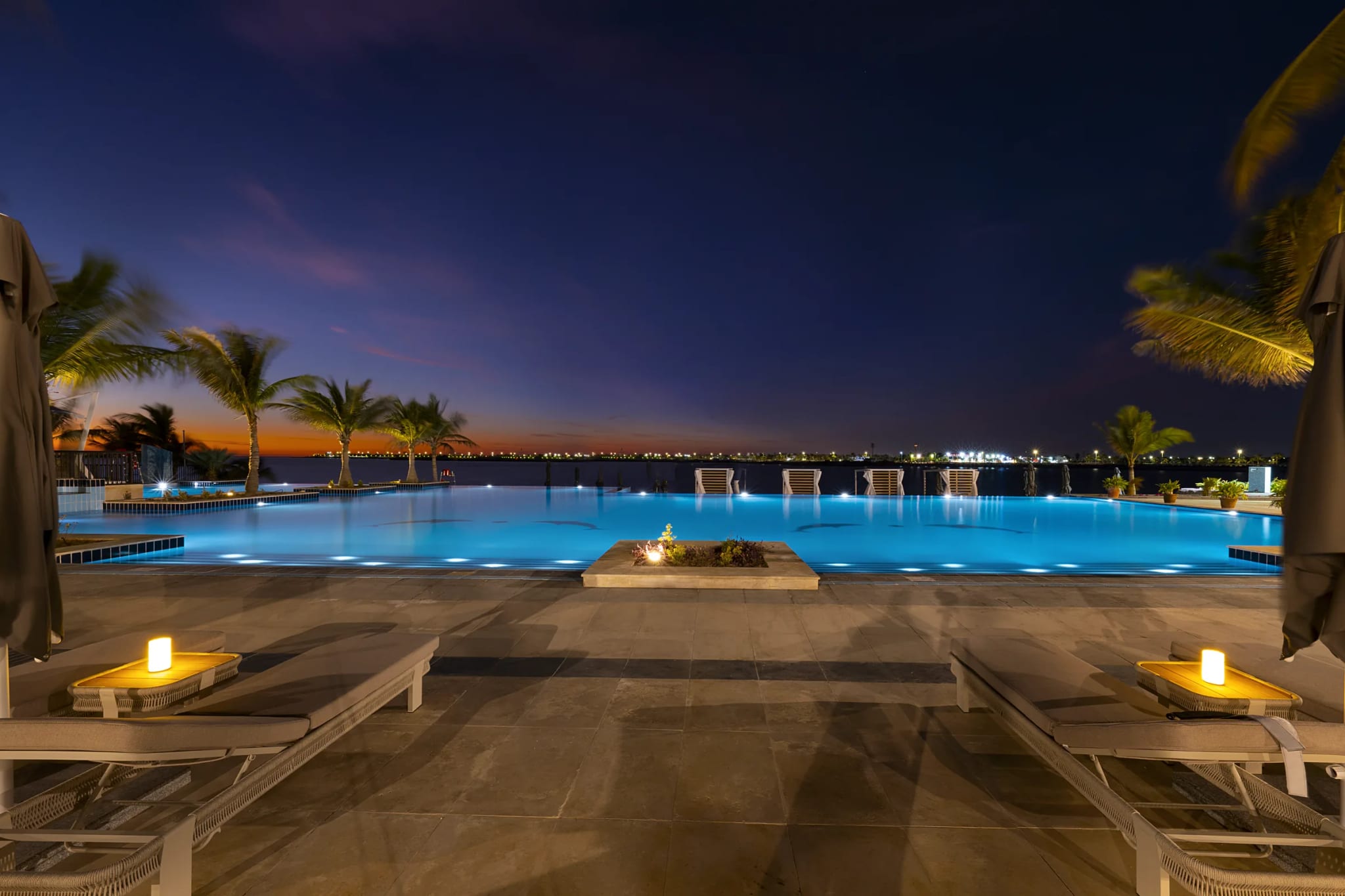The lit infinity pool at Sariya Hotel after dark